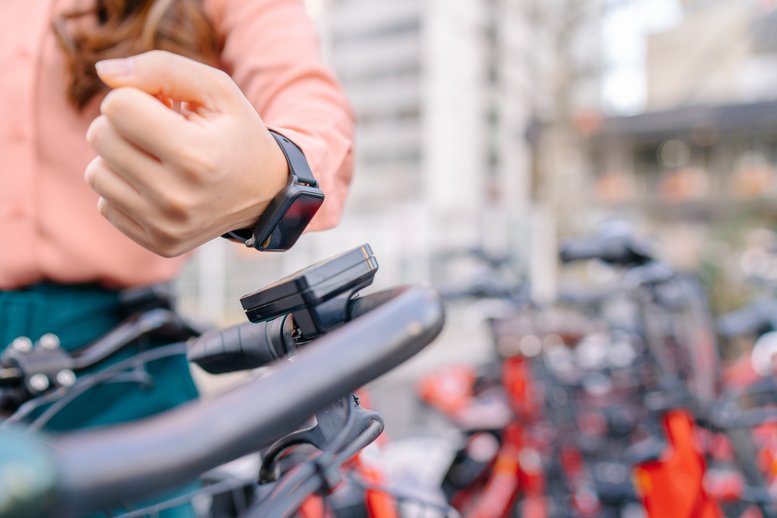 A cyclist connects their smart watch to their smart bicycle