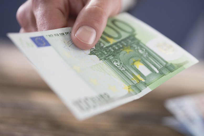 Eine Herrenhand, die europäische Banknoten hält 
