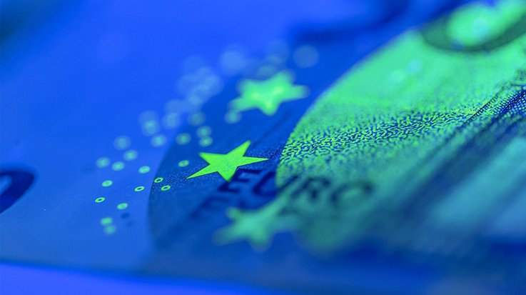 Großaufnahme einer in Schwarzlicht leuchtenden Eurobanknote