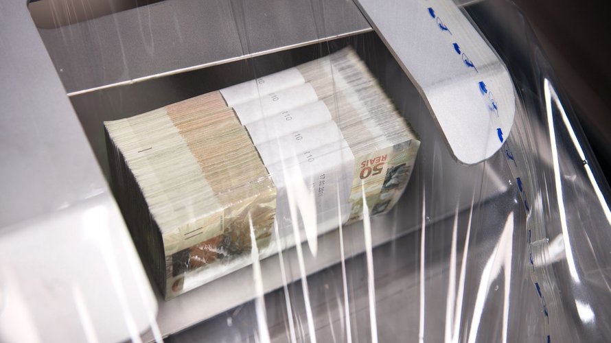 Ein Stapel Banknoten wird in einem Banknotenbearbeitungssystem foliert