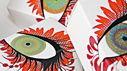 Drei Papierschachteln mit jeweils einem kunstvoll dargestellten Auge darauf