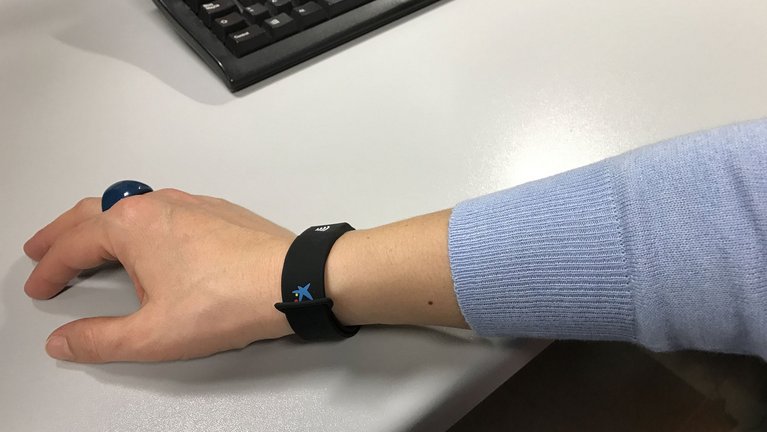 A wristband on the wrist of a person sitting at a desk