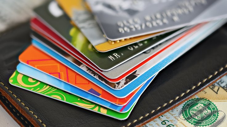 Credit cards are stacked on a wallet