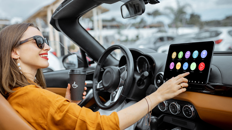 Frau bedient per Touchscreen das Cockpit ihres Cabriolets