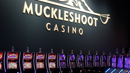 Oberhalb von einer Reihe Spielautomaten steht in großer Aufschrift 'Muckleshoot Casino'