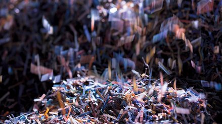 Small shreds of shredded banknotes fall in a pile