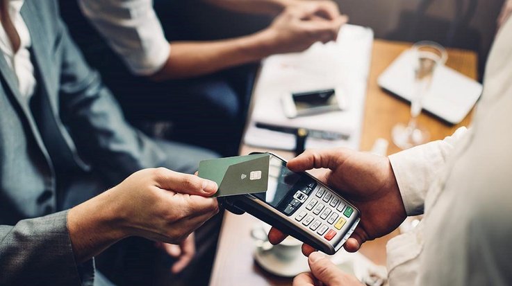 Ein Geschäftsmann bezahlt kontaktlos mit seiner Kreditkarte in einem Restaurant