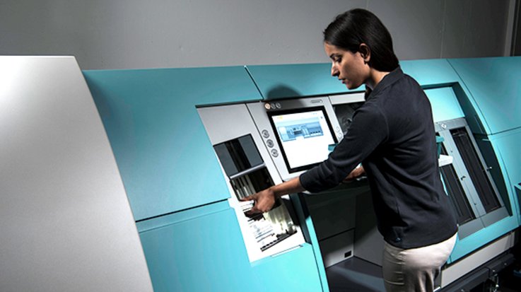 A woman works on a banknote processing system from G+D