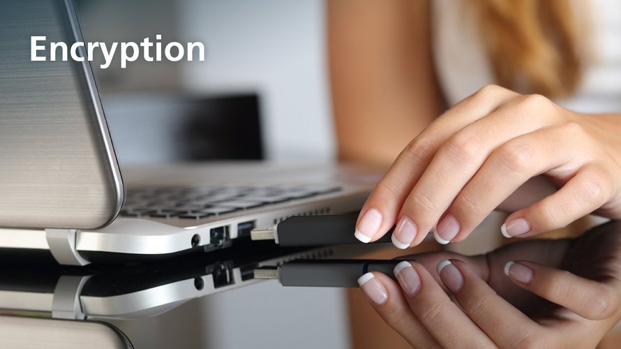 A female person inserts a USB stick into a laptop. The picture says 'encryption'.