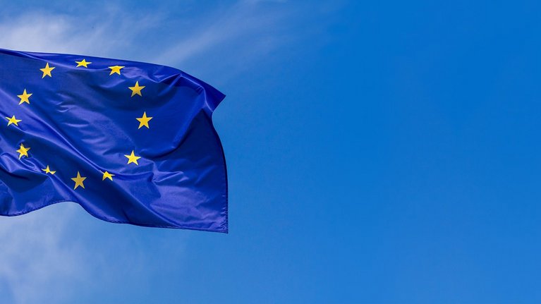 Waving European flag against blue sky