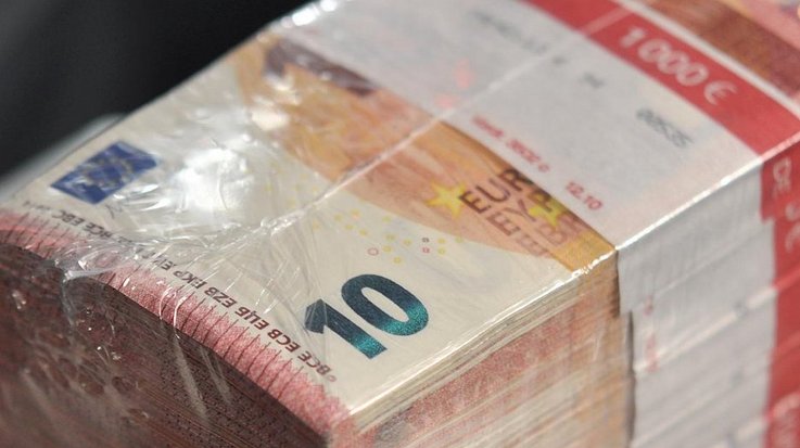 Several stacks of banded €10 banknotes are held together by a plastic foil