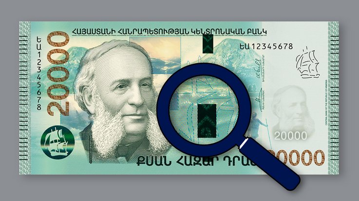 An Armenian 20,000 dram banknote with a magnifying glass pointed at it