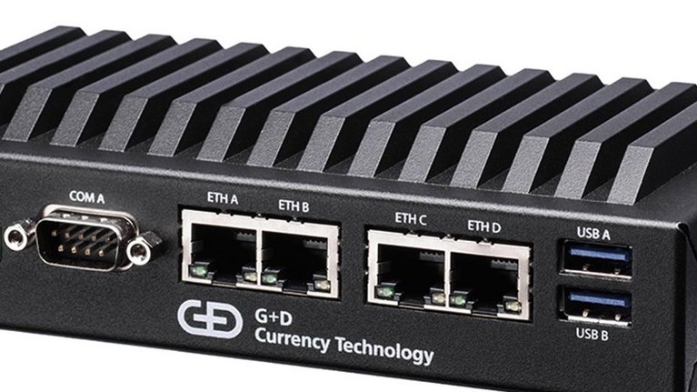 Eine kleine schwarze Box mit USB-, und diversen Netzwerkkabelanschlüssen und der Aufschrift G+D Currency Technology