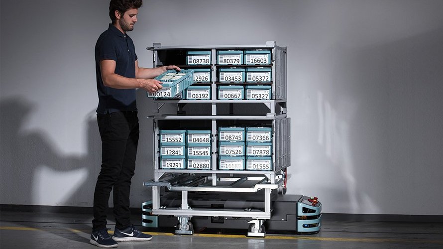 A man fills NotaTrays filled with banknotes into large plastic boxes for transportation