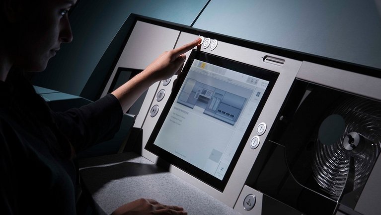 A person operates the BPS® M3 banknote processing system via touchscreen