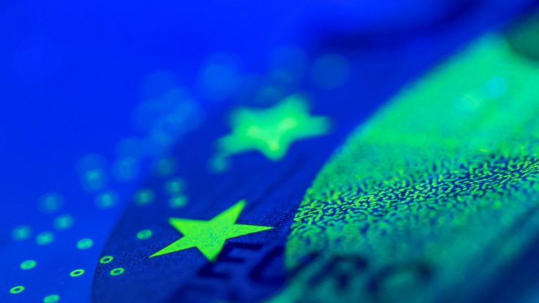 Close up of euro banknote glowing in black light
