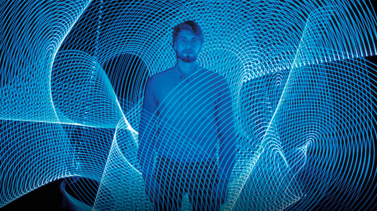 Young man surrounded by computer simulated web spinning