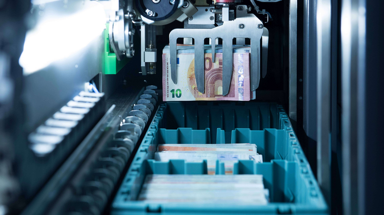 Foto aus dem inneren einer Maschine die automatisiert Geldscheine verarbeitet