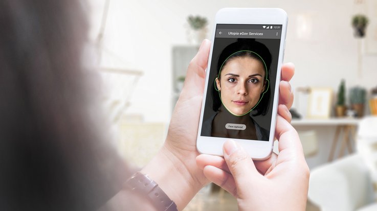 A woman uses identity authentication via smartphone-based facial recognition from G+D