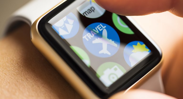 Großaufnahme des Screens einer Smartwatch mit einem Icon für eine Reise-App 