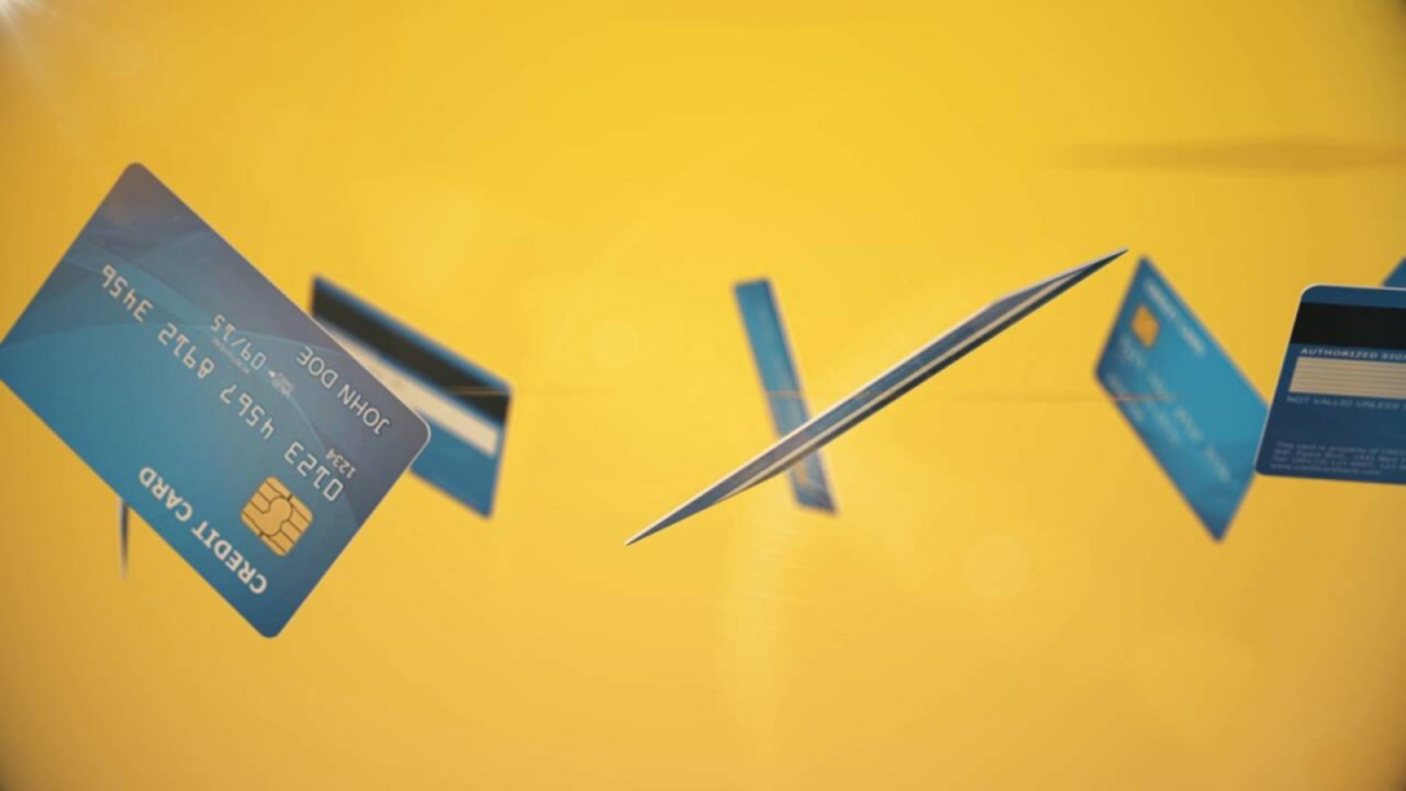 Einige blaue Kreditkarten schweben vor einem gelben Hintergrund durch den Raum