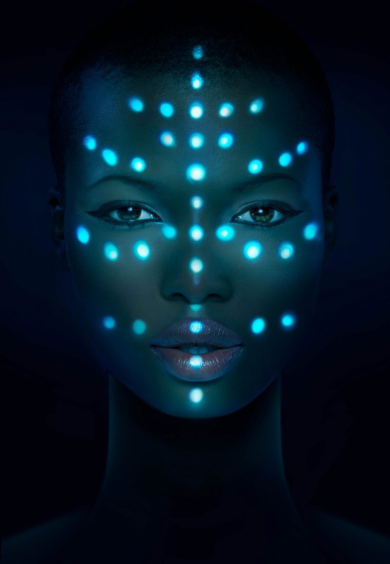 Leuchtende Laserstrahlpunkte auf dem Gesicht einer Frau symbolisieren die große Vision der KI