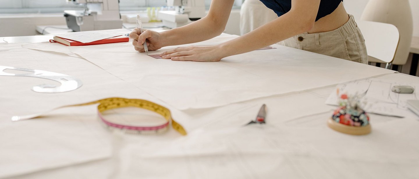 A woman working on a dressmaking table