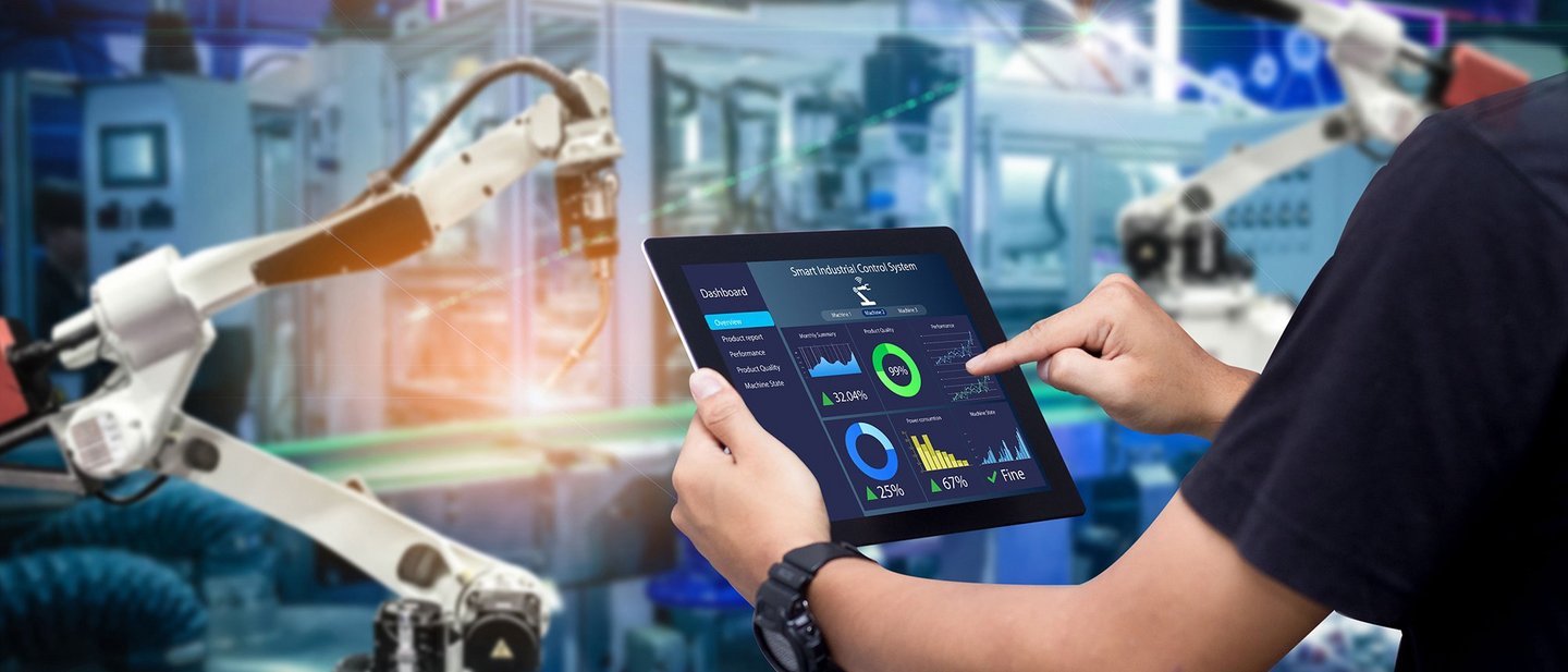 Close up of a man controlling smart manufacturing with a tablet
