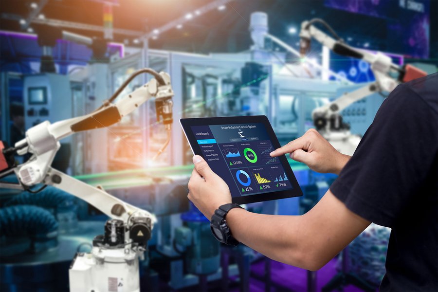 Close up of a man controlling smart manufacturing with a tablet