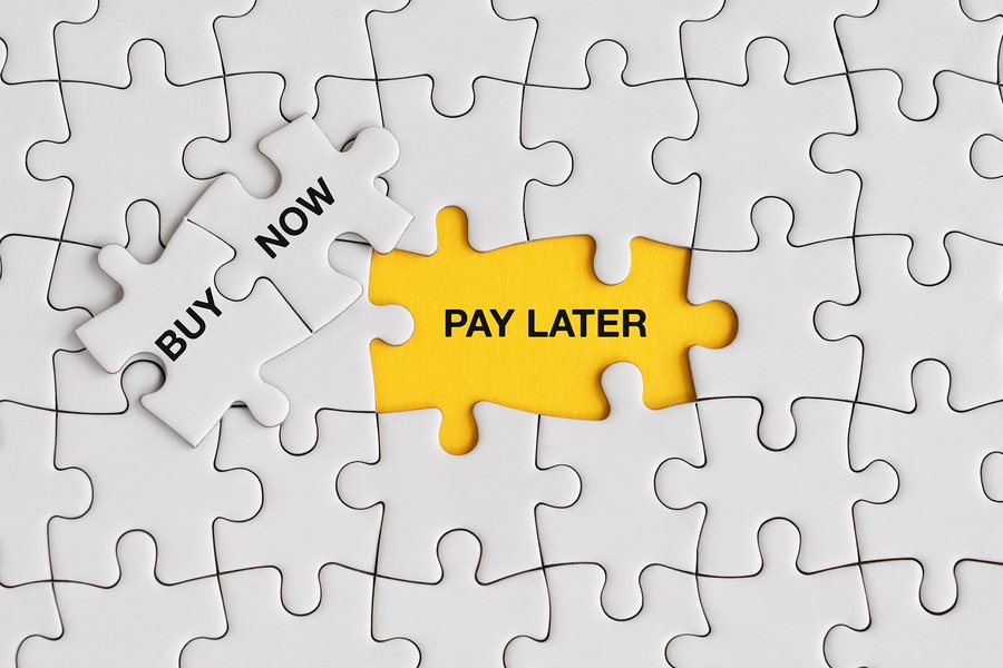 Schriftzug „Buy Now, Pay Later“ auf einem Holzpuzzle