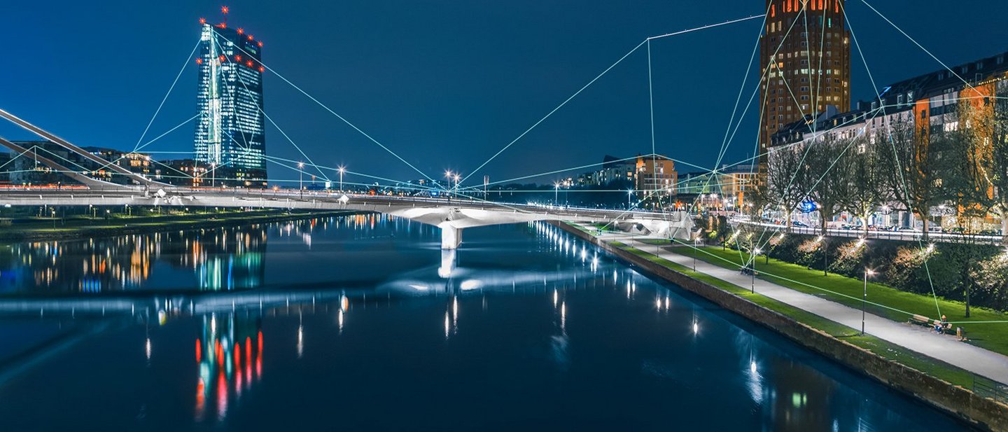Blockchain-Netzwerk, das sich über die Frankfurter Skyline und die Europäische Zentralbank bei Nacht erstreckt