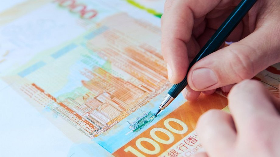 Zahlung, Design Thinking für die Banknotenproduktion, eine Banknote und ein Stift in der Hand