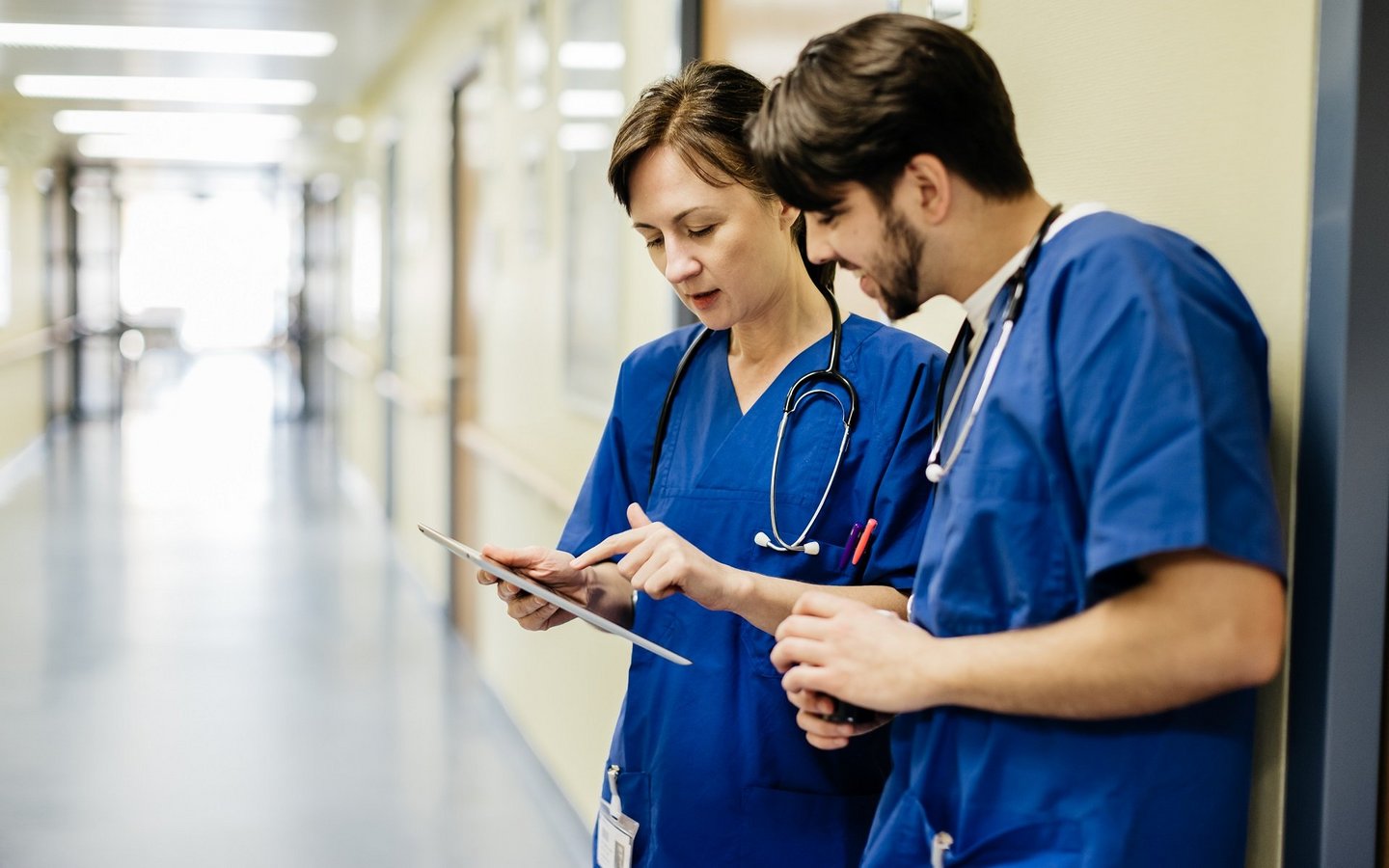 Medizinisches Personal schaut auf ein Tablet in einer medizinischen Einrichtung