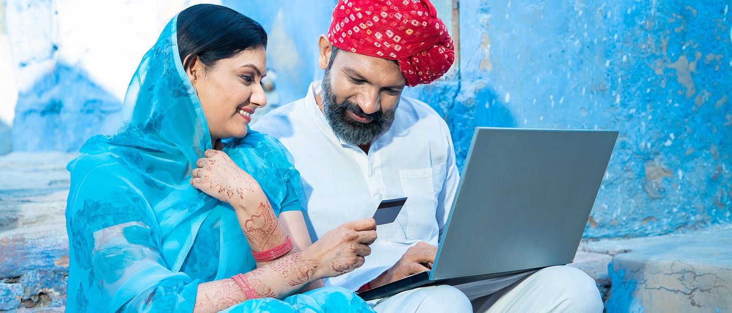An Indian couple looks at a laptop