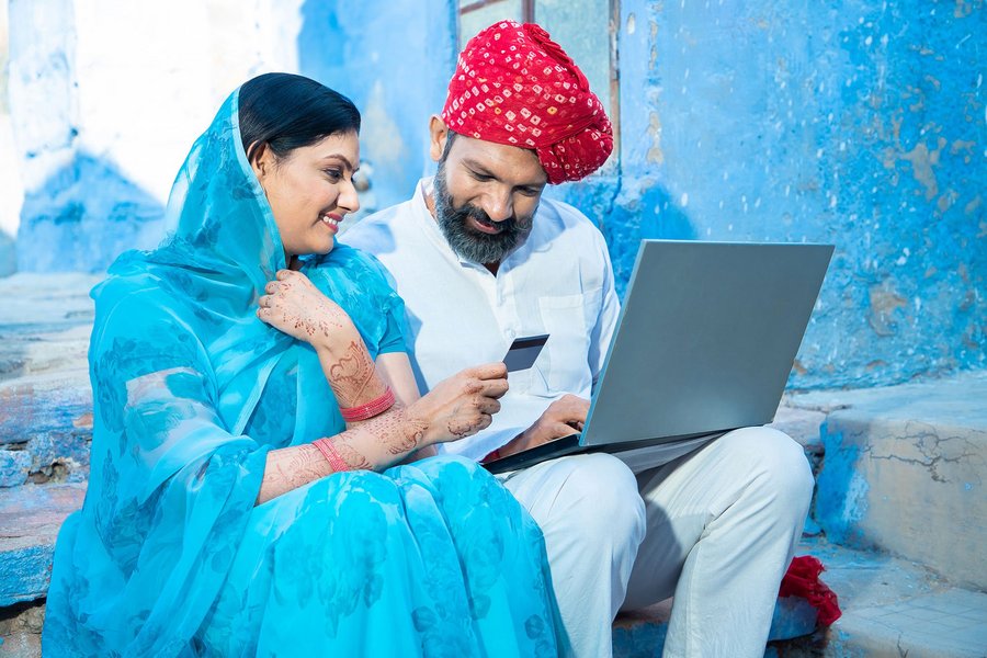 An Indian couple looks at a laptop