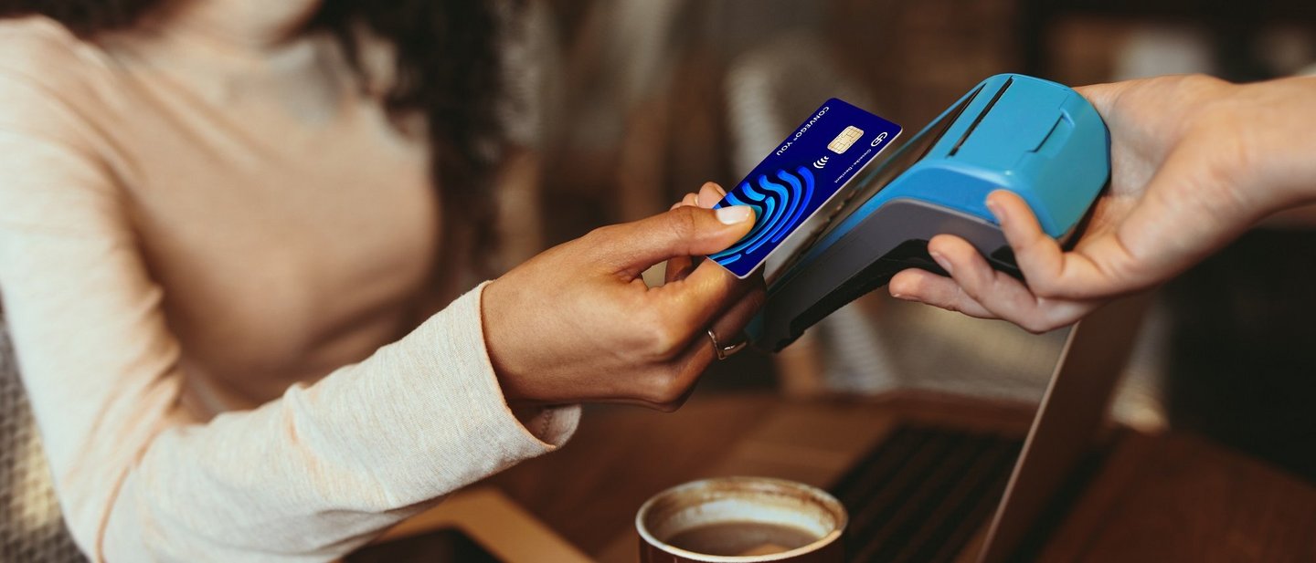 A woman pays for a coffee contactless with her credit card