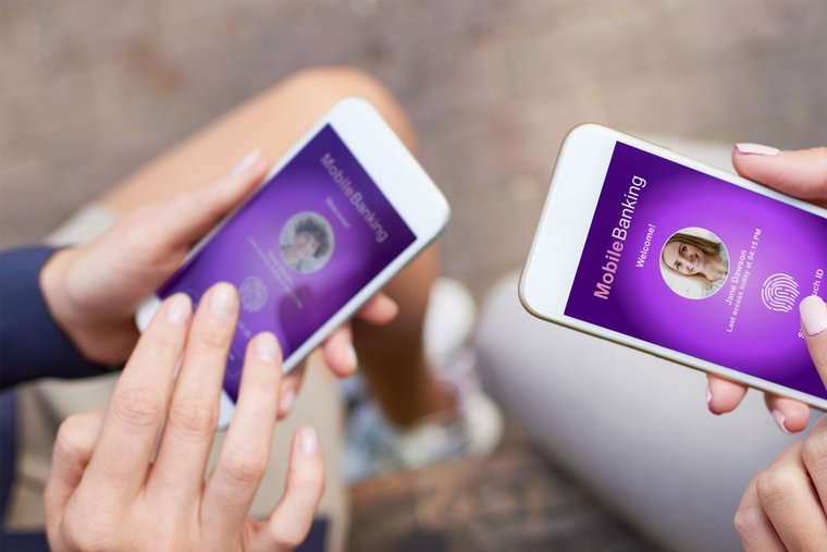 Blick von oben auf Geschäftsfrauen, die eine App für mobiles Banking nutzen und eine App mit biometrischer Authentifizierung starten – alles Möglichkeiten des Online-Bankings