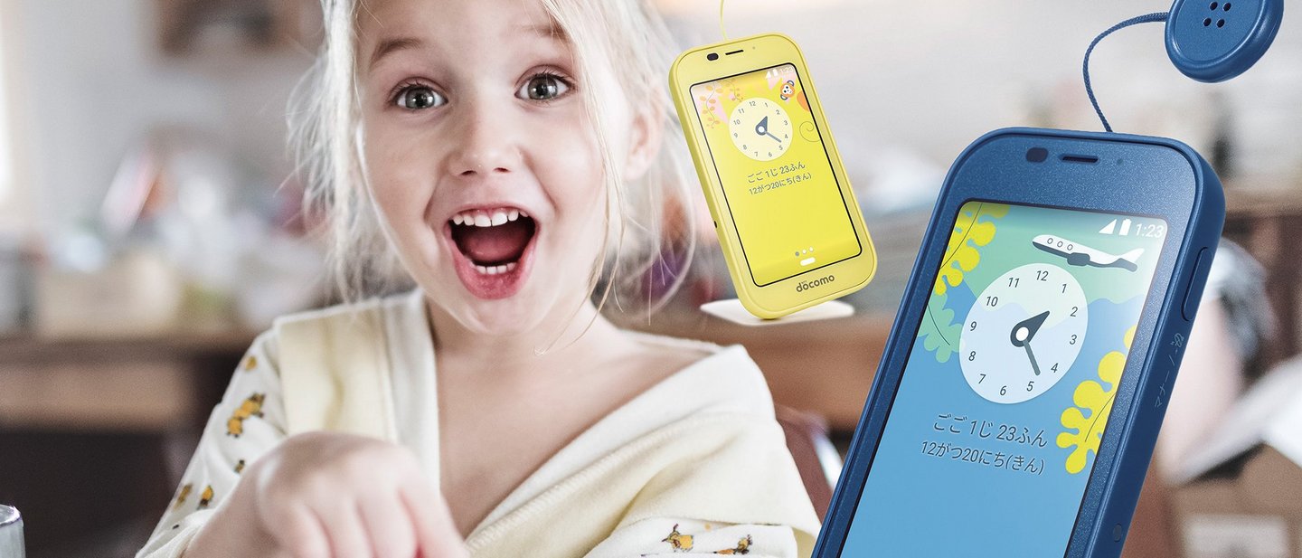 Smiling girl who is excited using a kids’ mobile phone