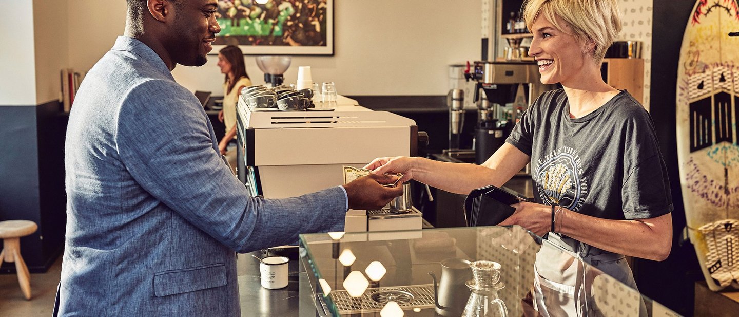 Payment scene between a black man and a white woman in a coffee shop