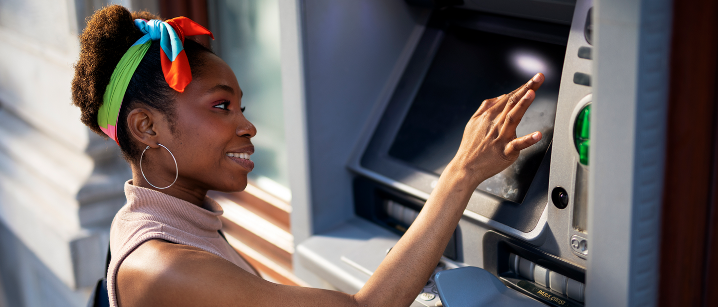 Eine Frau benutzt einen Geldautomaten