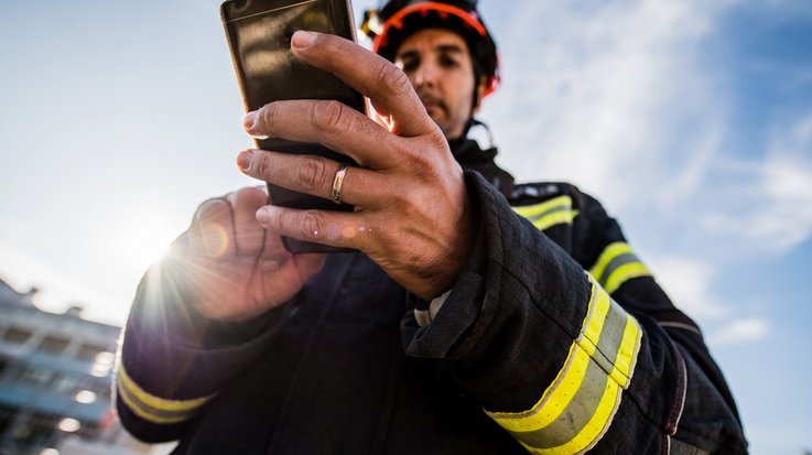 Feuerwehrmann im Einsatz mit Handy