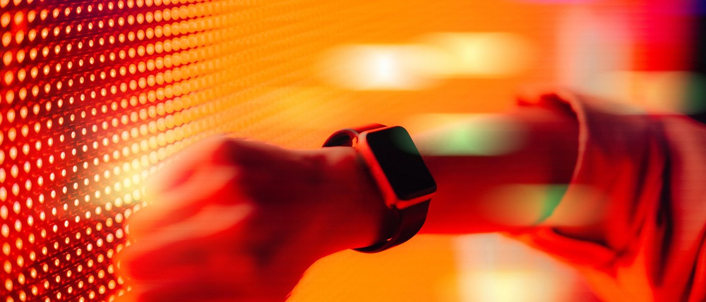 Women holds her smartwatch against a digital wall