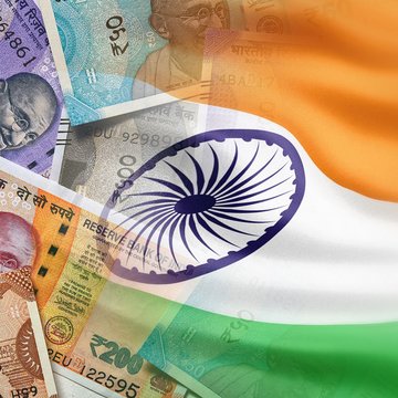 Indian cash next to an Indian flag